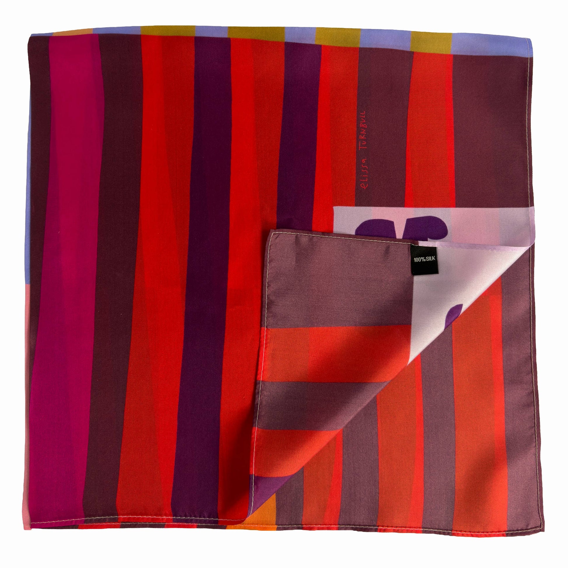 Folded Red Colorblock silk scarf showing deep red, orange, pink, and burgundy stripes with Voyager Silk tag detail.