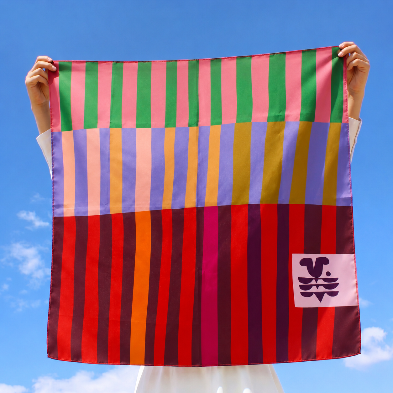 Red Colorblock 100% silk scarf held open outdoors against a blue sky to show the full striped colorblock design.