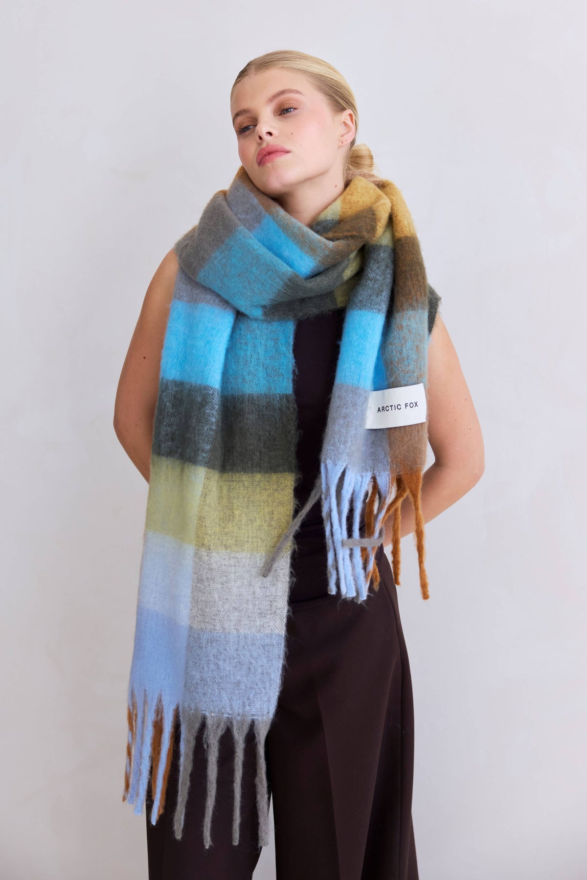 Woman wearing the oversized Reykjavik Scarf in Blue/Orange check with fringed ends