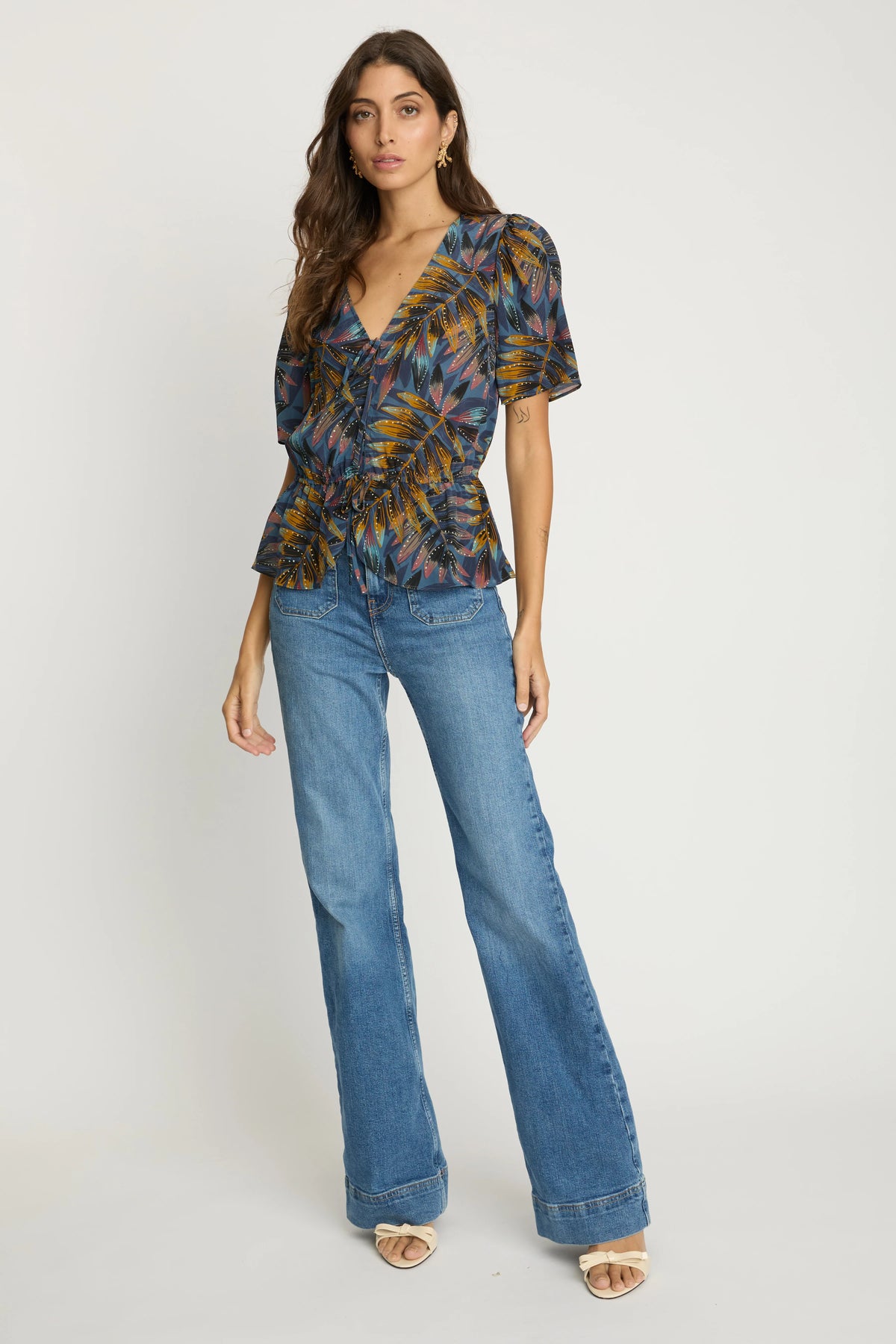 Model wearing the Rhea Top in Midnight Palm with wide-leg blue jeans, shown in a full-length front view.