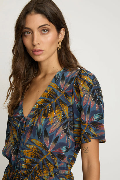 Close-up of the Rhea Top highlighting the V-neckline, front tie, flutter sleeve, and multicolored botanical print.