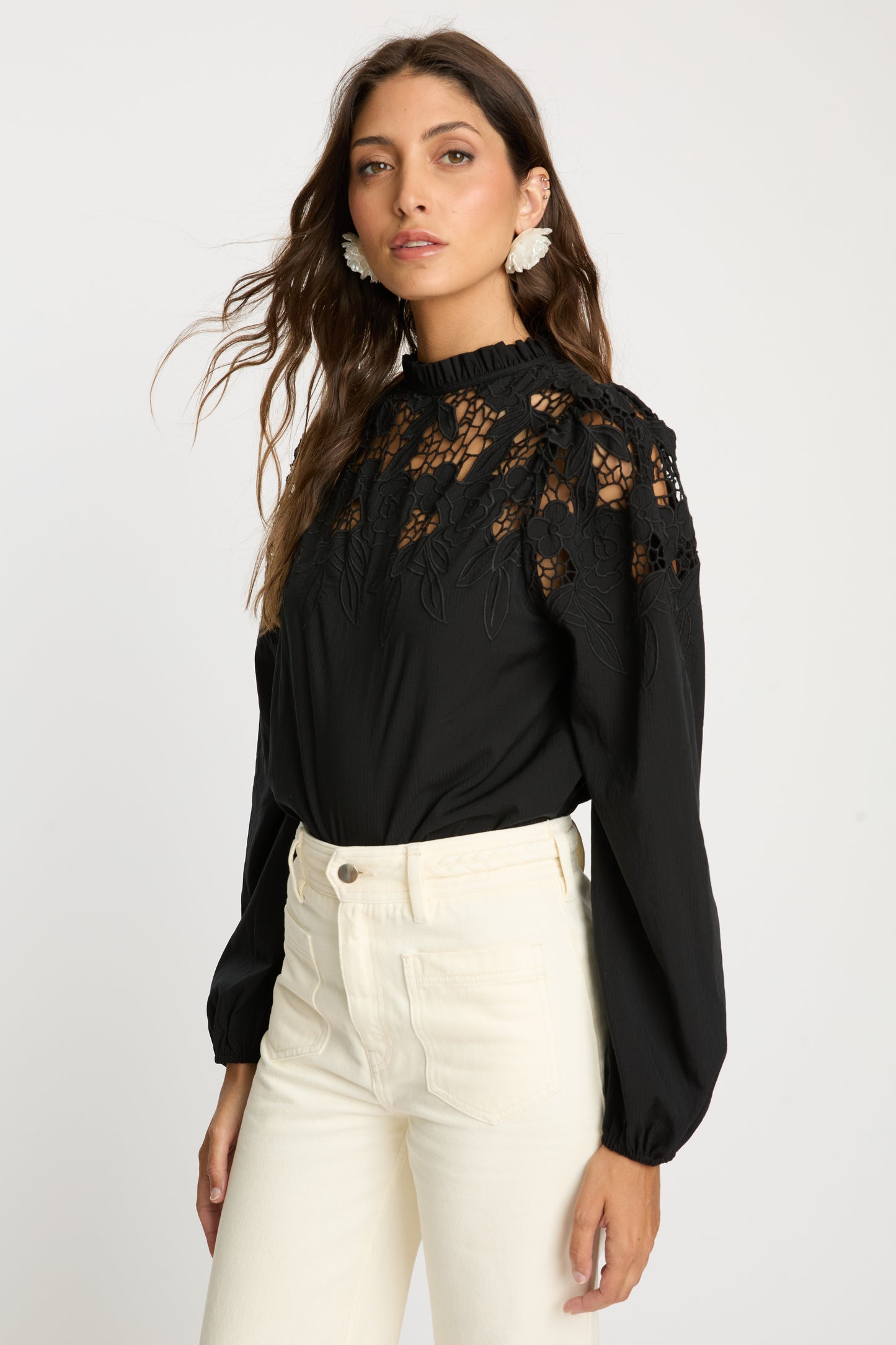 Angled front view of the Riana Reversible Top in black showcasing embroidered floral lace detailing across the shoulders and bodice, sheer panels, and voluminous long sleeves.