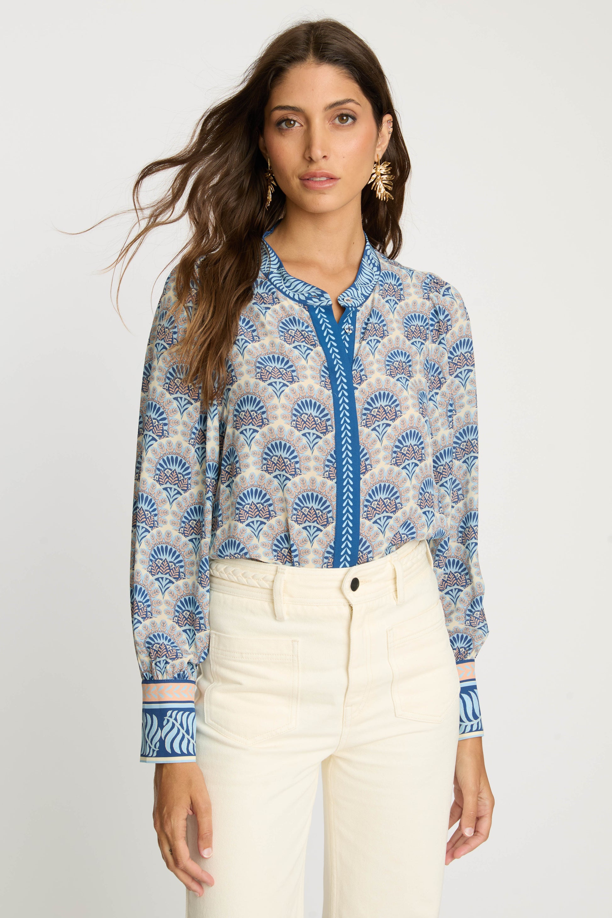 Front view of the Riley Top in Boho Deco featuring a soft blue and beige deco-inspired print, mandarin collar, V-neck opening with contrasting blue trim, and relaxed long sleeves.