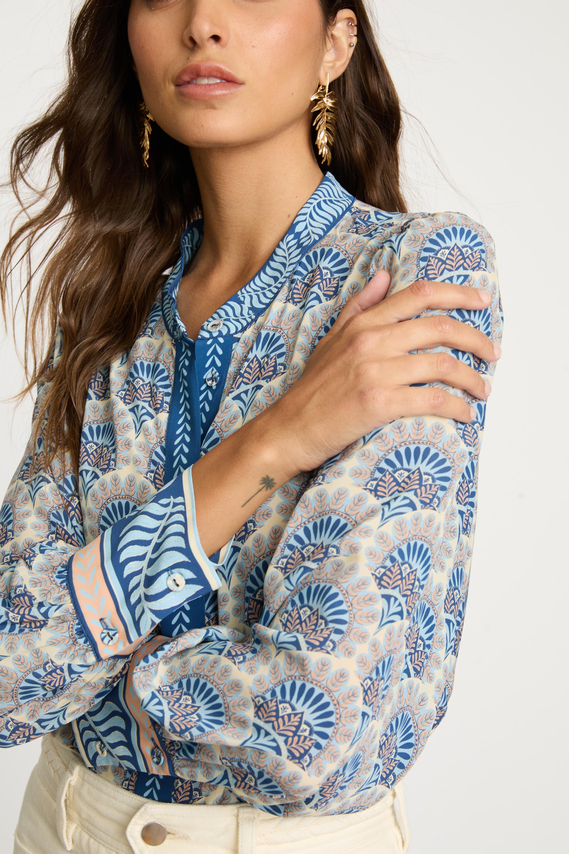 Close-up detail of the Riley Top in Boho Deco showing the intricate blue and beige print, contrasting embroidered placket, patterned cuffs, and lightweight viscose fabric texture.