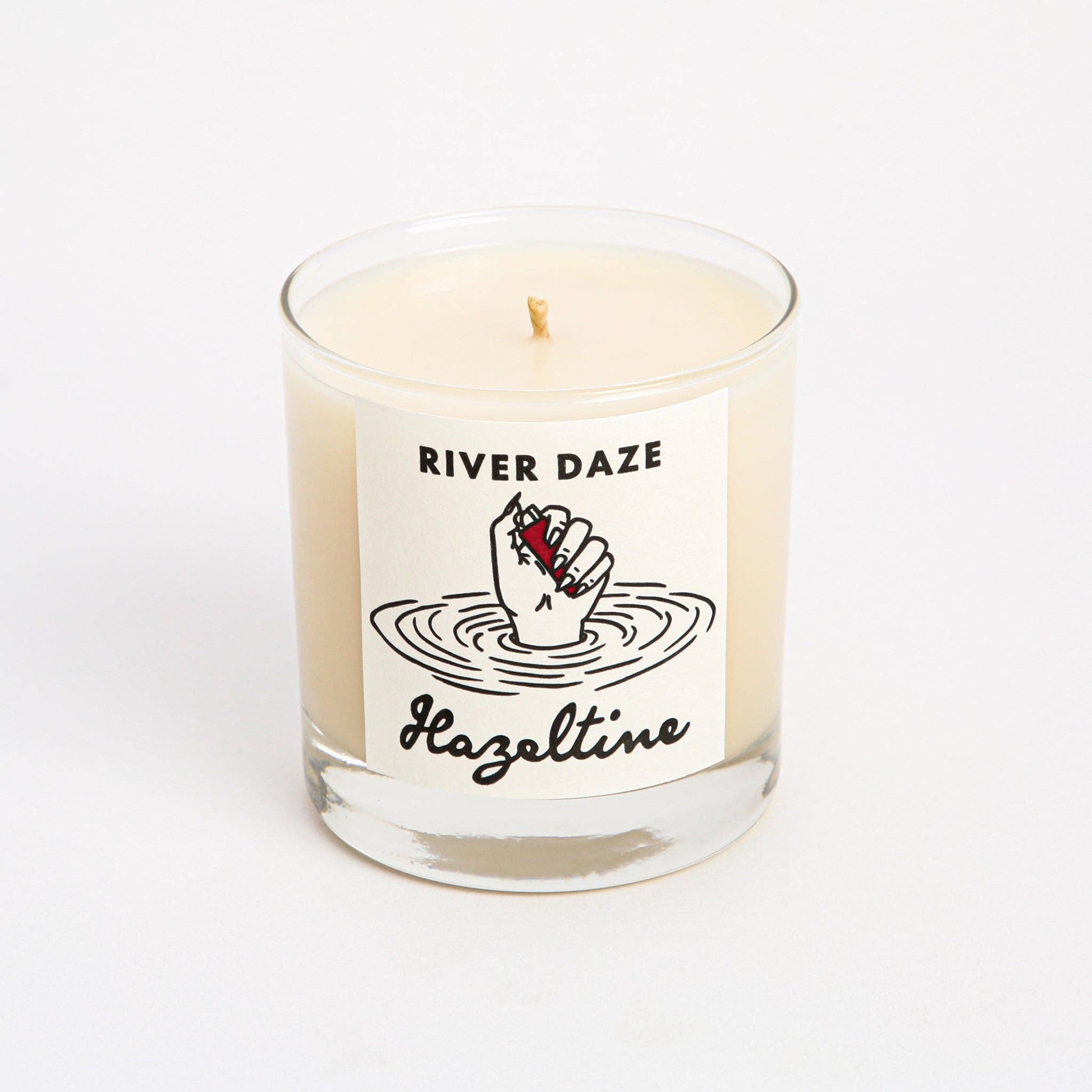 Front view of River Daze scented candle in a clear glass jar with Hazeltine label.