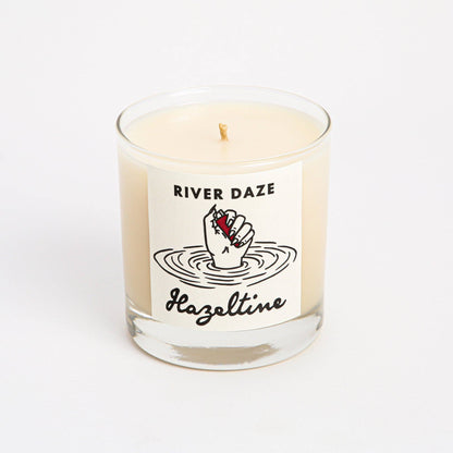 Front view of River Daze scented candle in a clear glass jar with Hazeltine label.
