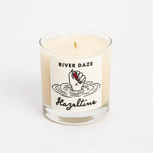 Front view of River Daze scented candle in a clear glass jar with Hazeltine label.