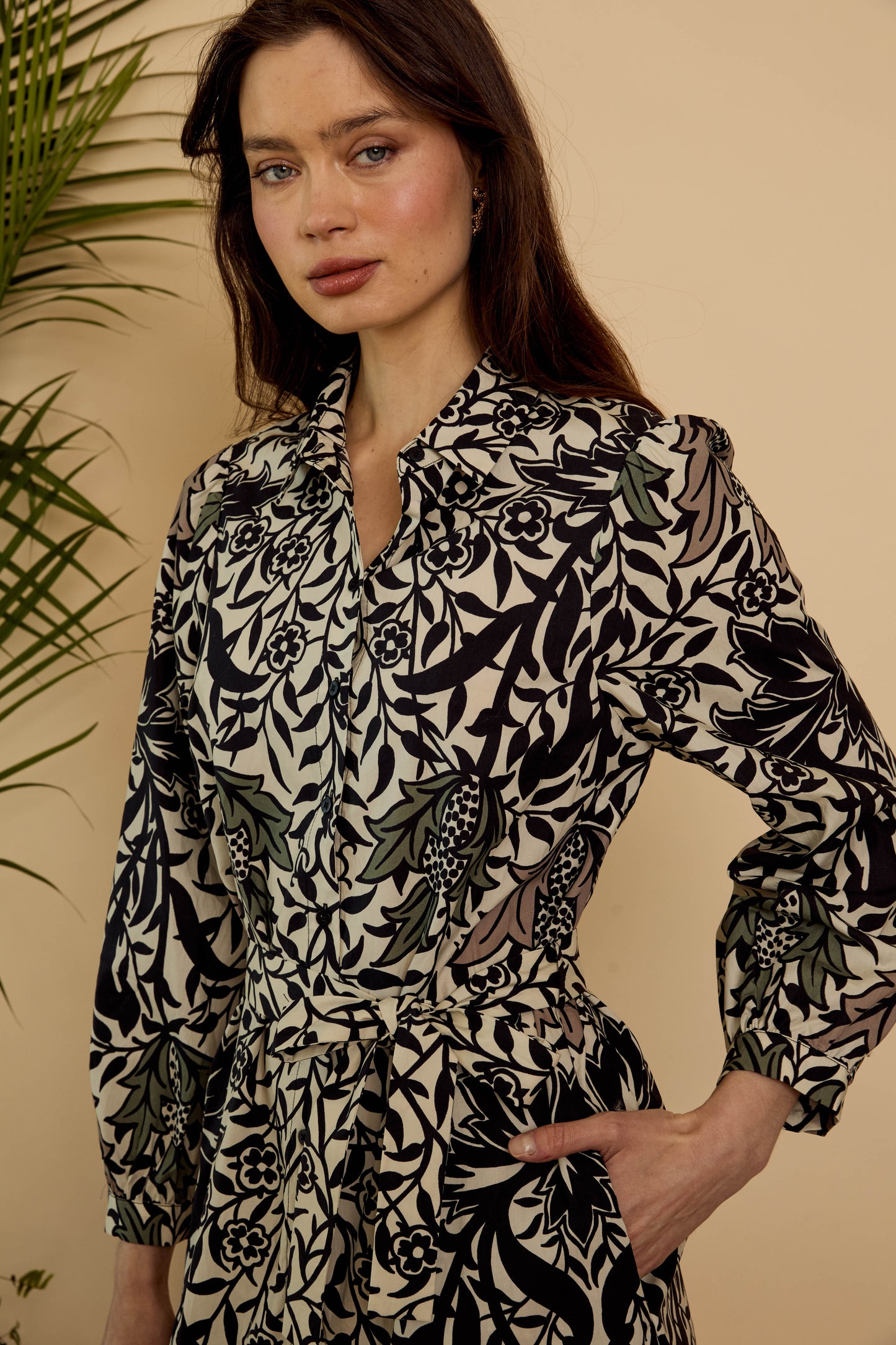 Close-up of the Roan Dress in Safari Garden Morning showing the pointed collar, button-front bodice, botanical print, and self-tie waist