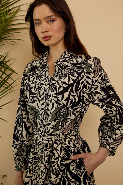 Close-up of the Roan Dress in Safari Garden Morning showing the pointed collar, button-front bodice, botanical print, and self-tie waist