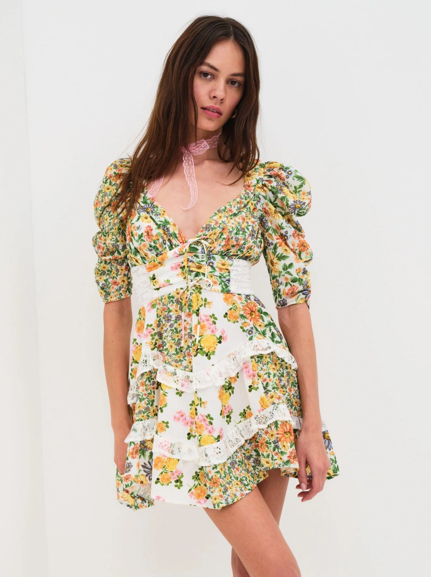 Front view of the Rosalyn Mixed Floral Print Mini Dress featuring mixed floral patchwork, puff sleeves, a shirred waist, lace trim, and a ruffled mini skirt.