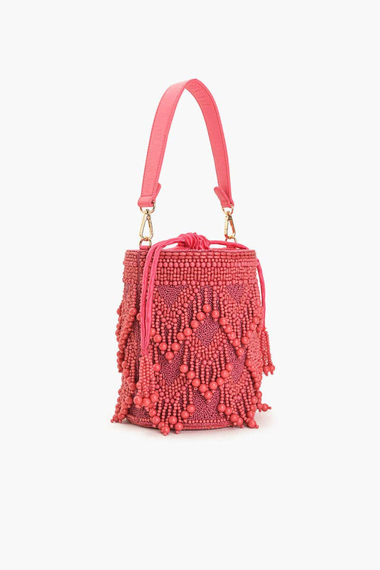 Side view of the Rose Eden Bucket Bag showing its structured bucket shape, pink beaded fringe, detachable handle, and tassel accents.