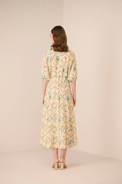 Back view of the Rosewood Midi Dress, showing the botanical print, midi length, puff sleeves, and softly structured silhouette.