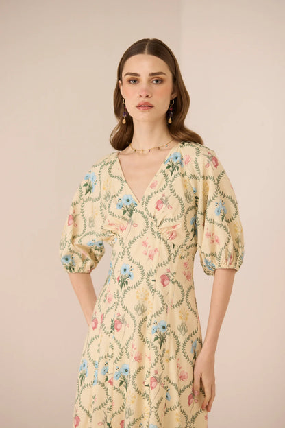 Close-up of the Rosewood Midi Dress showing the V neckline, soft puff sleeve, fitted bodice, and delicate botanical print.