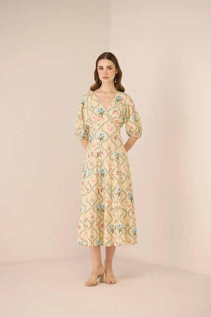 Model wearing the Rosewood Midi Dress in a romantic botanical print, shown from the front with a V neckline, puff sleeves, and flowing midi skirt.