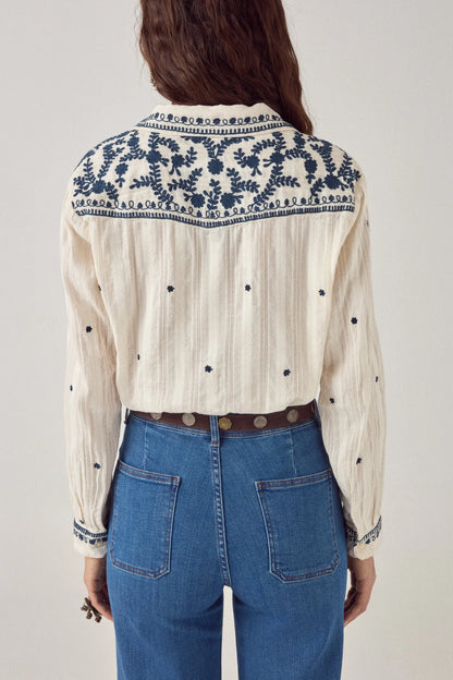 Back view of the Salinger Shirt in Cream Indigo showcasing embroidered shoulder yoke detailing, scattered navy motifs, and lightweight textured cotton fabric.