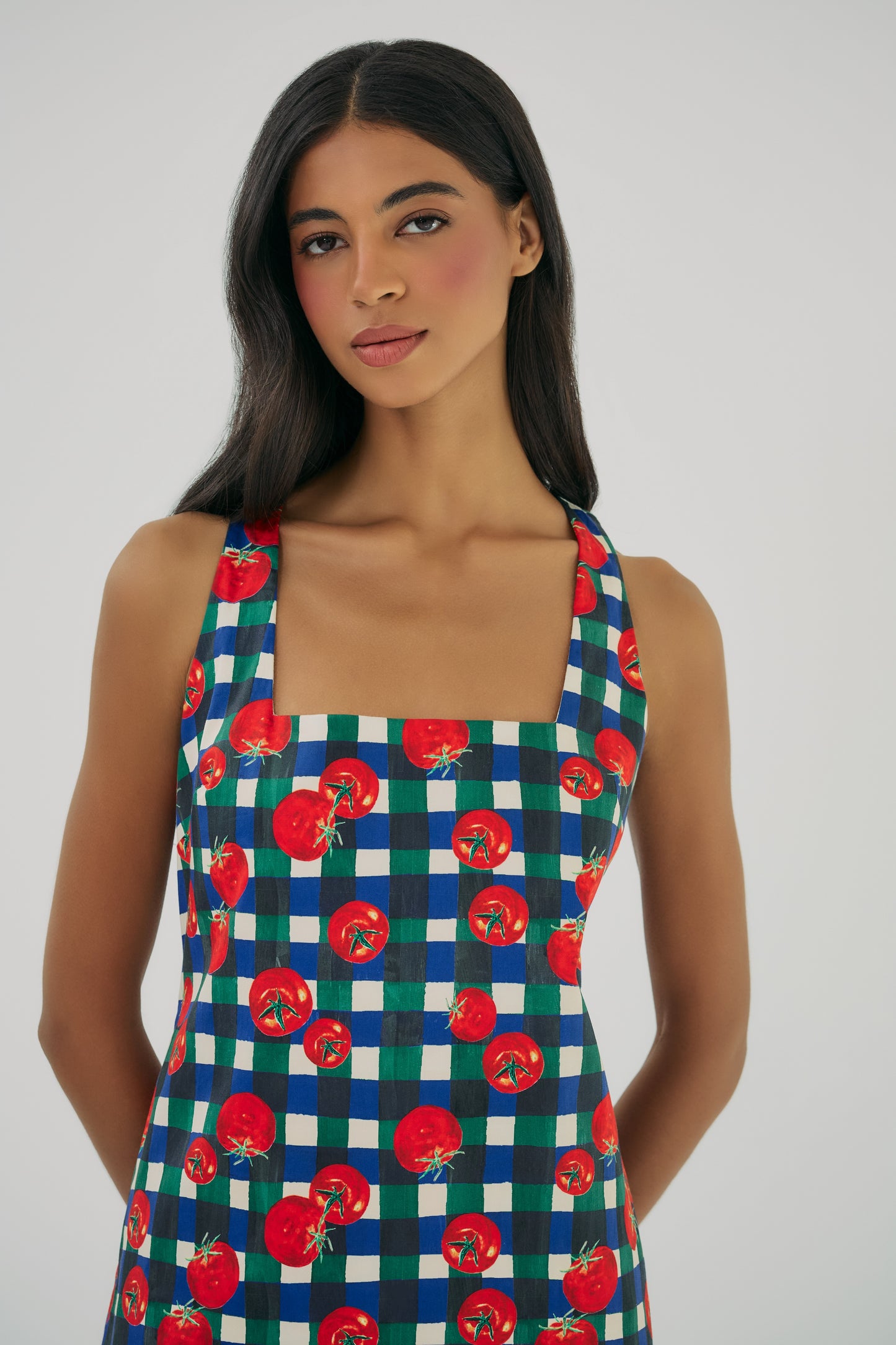 Close-up of Sara mini dress featuring square neckline wide straps and gingham print with red tomato pattern