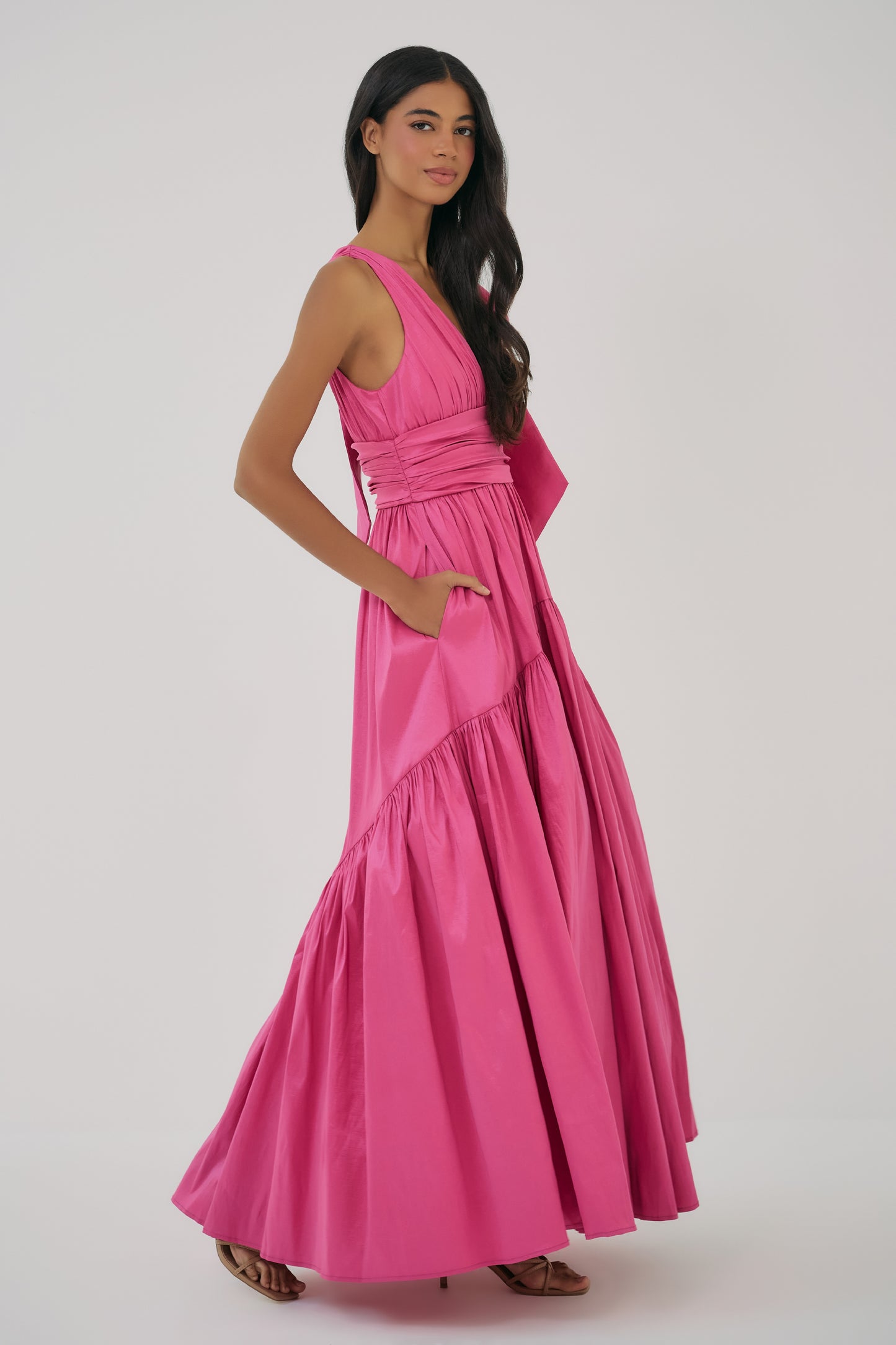 Full-length view of Selba Gown in Fuchsia featuring a fitted waist and flowing skirt with volume