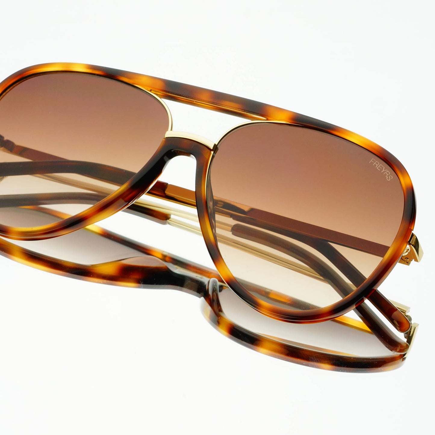 Shay Unisex Aviator Sunglasses in tortoise with gradient brown lenses, shown folded from an angled view.