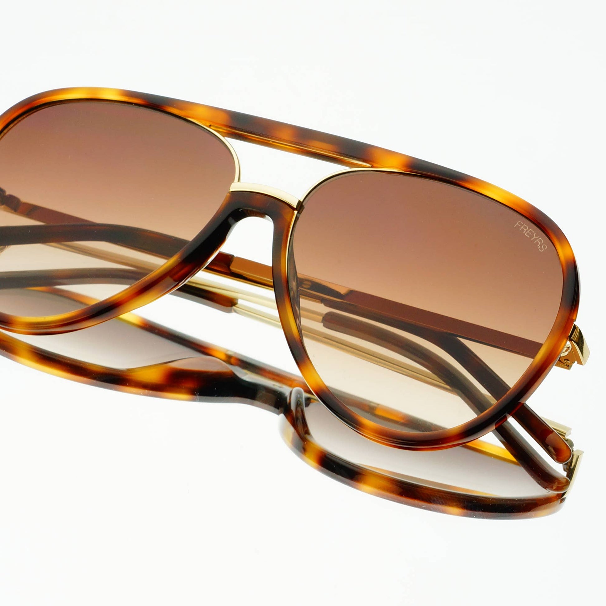 Shay Unisex Aviator Sunglasses in tortoise with gradient brown lenses, shown folded from an angled view.
