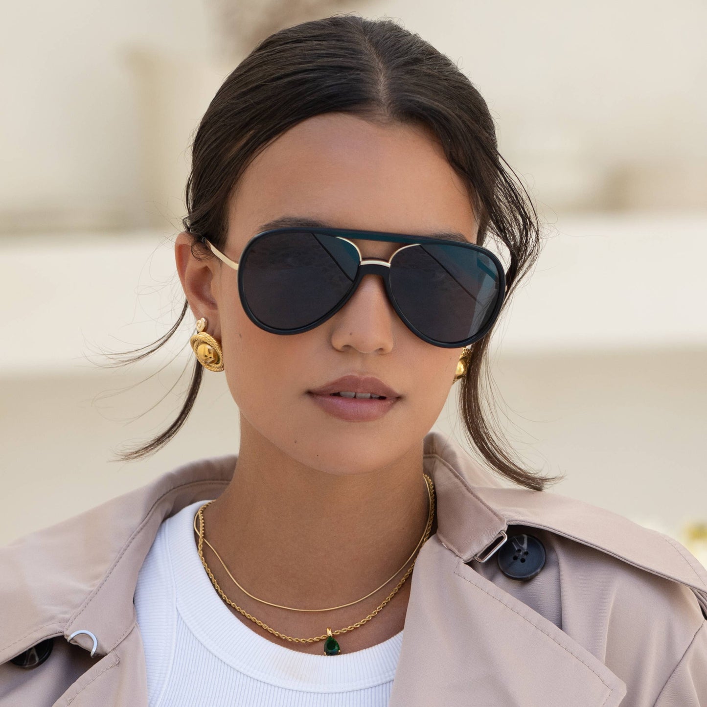 Model wearing the Shay black aviator sunglasses with dark lenses and gold detailing.