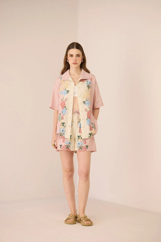 Full body view of model wearing the Shea Top styled open with the matching Shea Shorts in blush and cream floral print.