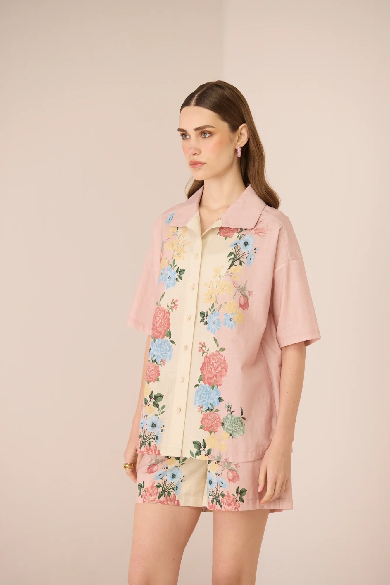 Side view of the Shea Top showing its relaxed shirt silhouette, short sleeves, and blush floral placement print.