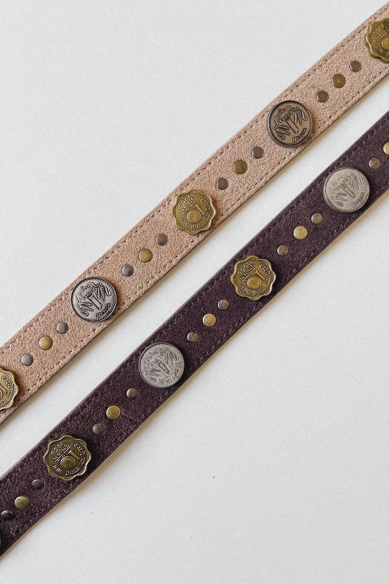 Close-up of the Sikka Belt in Tobacco showing brown suede leather with alternating gold and silver coin embellishments and metal stud detailing.