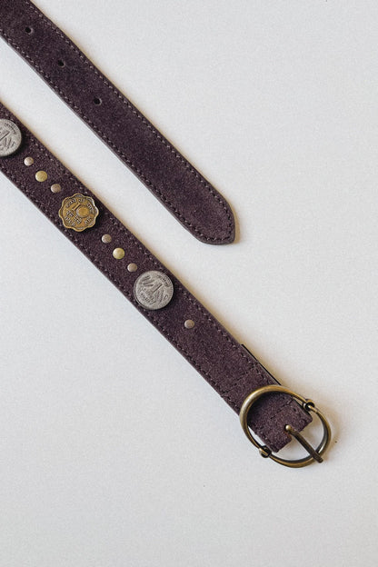 Full-length view of the Sikka Belt in Tobacco featuring a brown suede leather strap, mixed metal coin accents, and an antique brass oval buckle.
