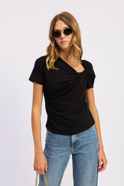 Model wearing the black Sloane Short Sleeve Shirt with an asymmetric gathered neckline and soft draped front detail.