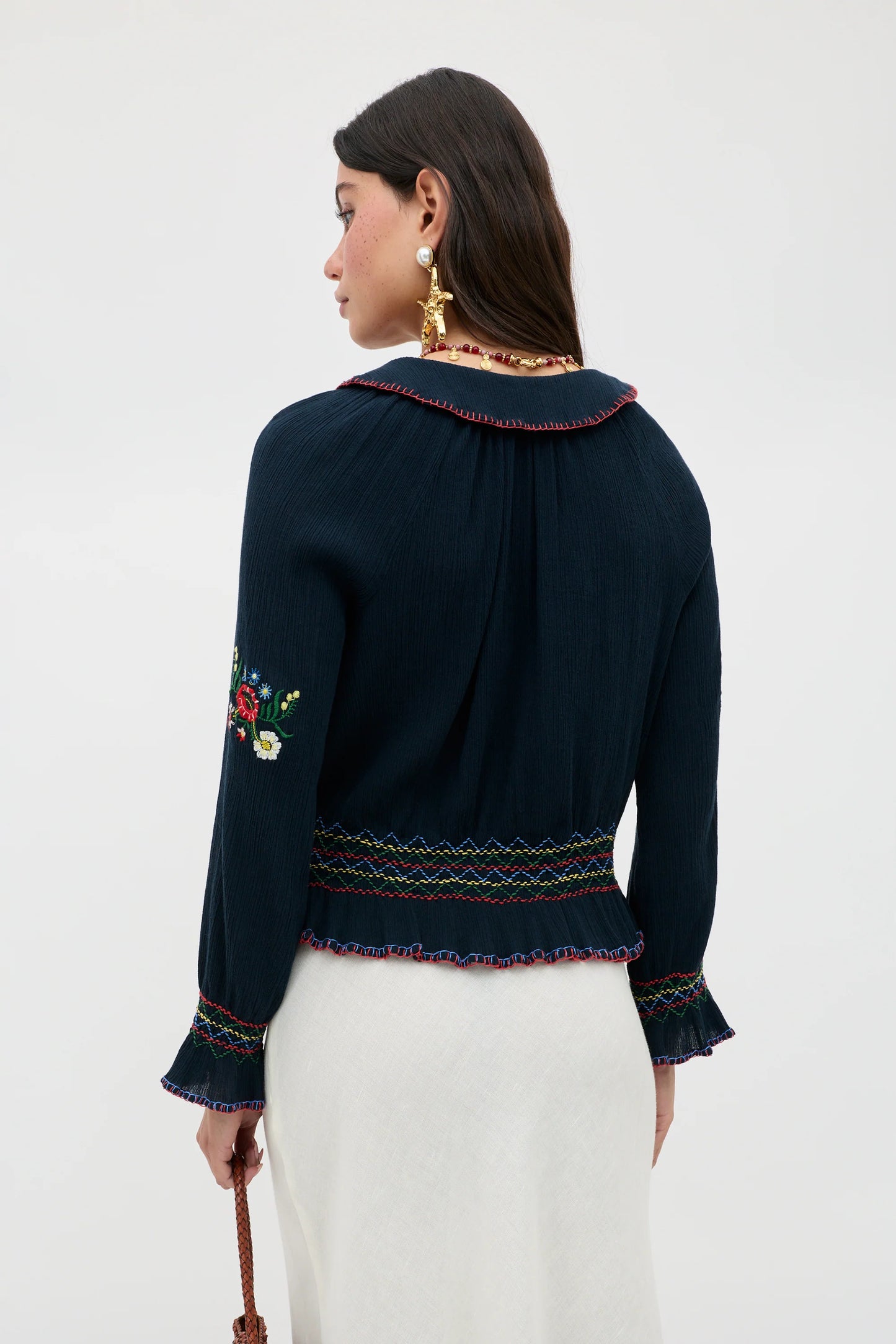 Back view of the Sofira Top featuring embroidered sleeve accents and gathered detailing at the waist