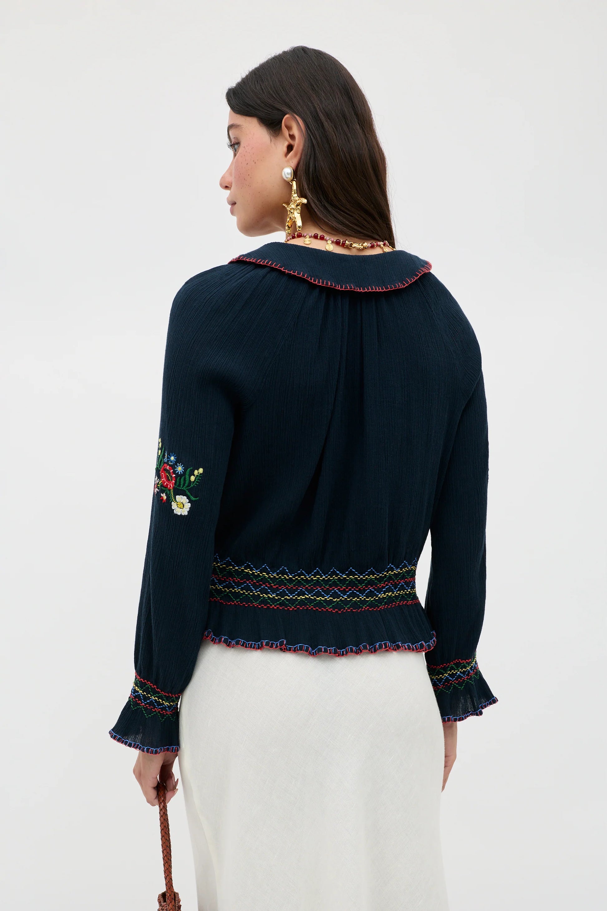 Back view of the Sofira Top featuring embroidered sleeve accents and gathered detailing at the waist