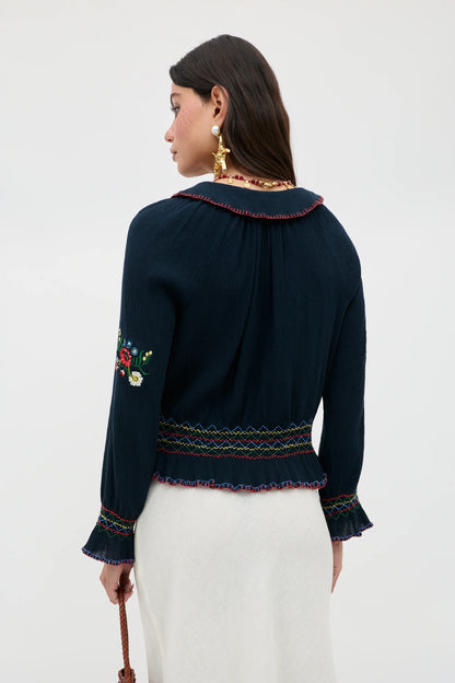 Back view of the Sofira Top featuring embroidered sleeve accents and gathered detailing at the waist