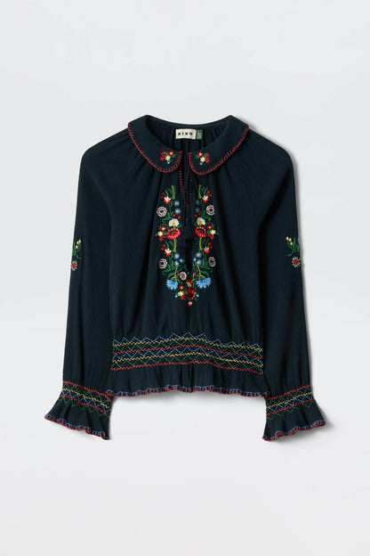 Flat lay of the navy Sofira Top with colorful floral embroidery, tie-neck detail, and ruffled cuffs