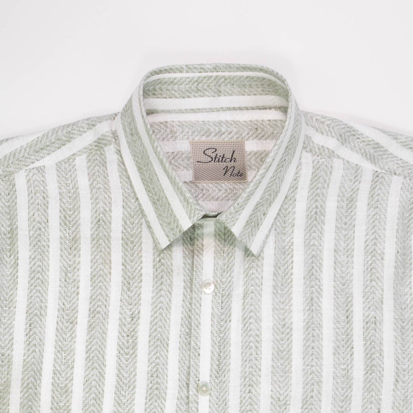 Close-up of the Striped Linen Shirt featuring a classic collar, mother-of-pearl buttons, and sage green vertical stripes.