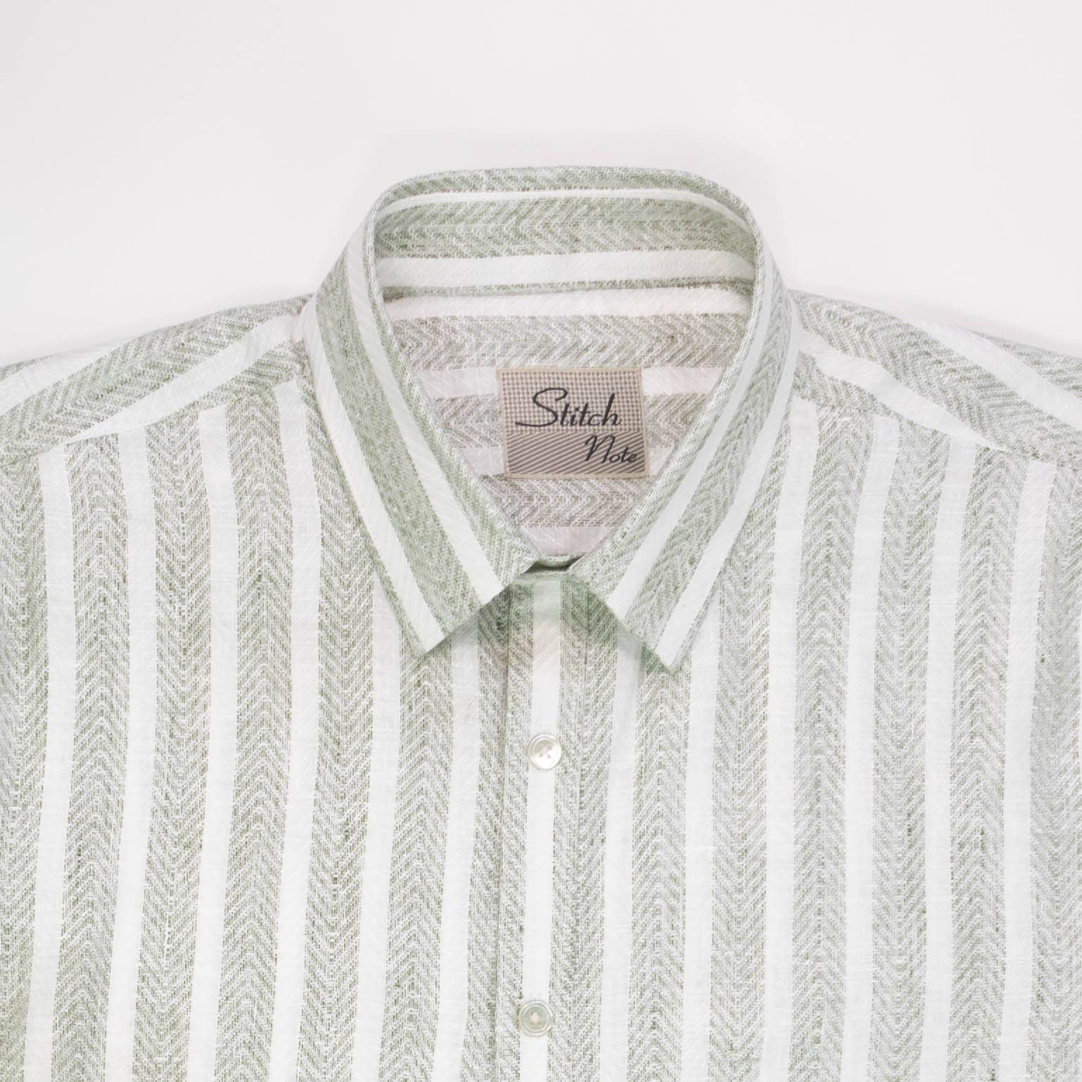 Close-up of the Striped Linen Shirt featuring a classic collar, mother-of-pearl buttons, and sage green vertical stripes.