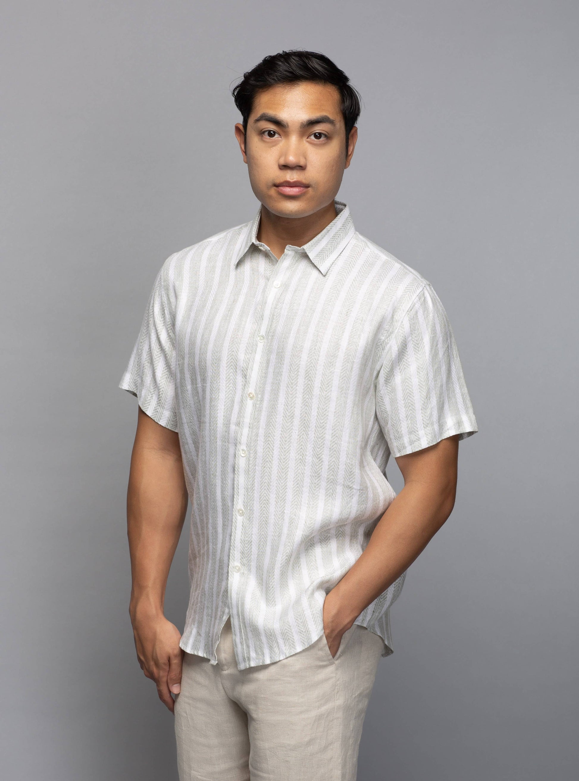 Model wearing the striped linen shirt in a relaxed classic fit with one hand in his trouser pocket.