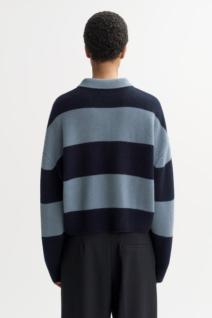Back view of the Striped Polo Shirt in Retro Blue featuring bold navy and blue horizontal stripes, chunky cashmere knit texture, and a cropped relaxed fit.
