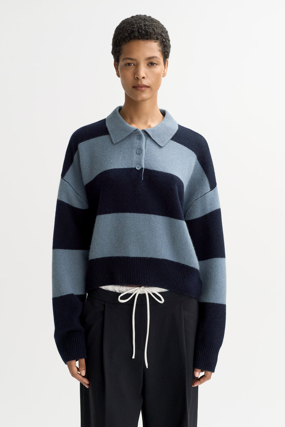 Front view of the Striped Polo Shirt in Retro Blue with bold horizontal stripes, cropped fit, and relaxed long sleeves in luxurious chunky cashmere knit.