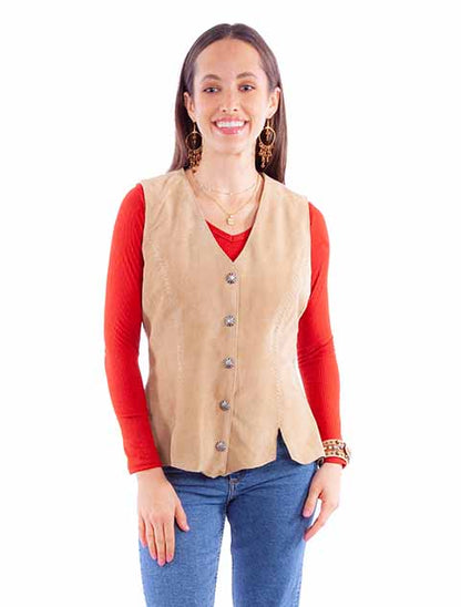 Model wearing a tan suede concho button vest with antique silver buttons, layered over a red long sleeve top and blue jeans.