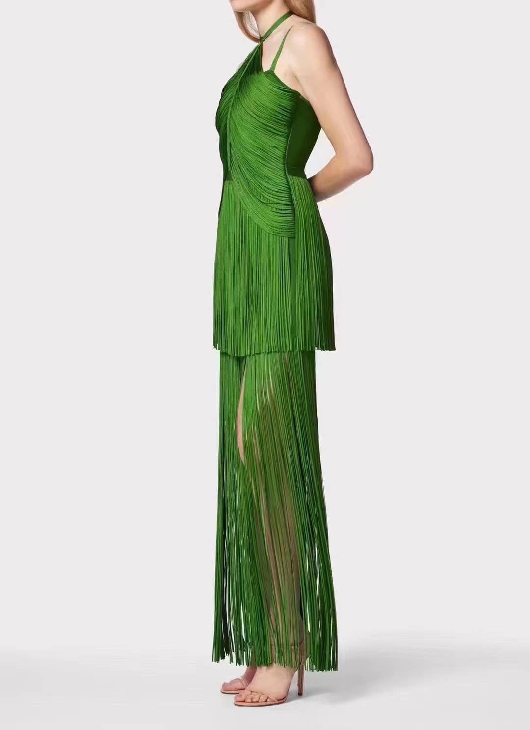Side profile of the emerald green fringe maxi dress featuring layered fringe panels, halter neckline, and lightweight flowing movement.