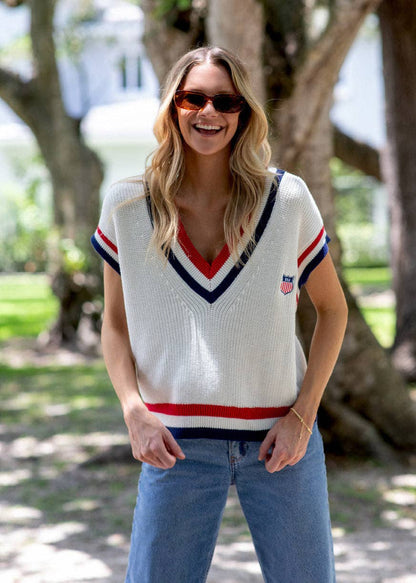 Model wearing the American Shield sweater vest with light wash denim in an outdoor setting.