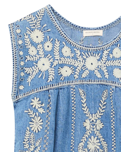 Close-up detail of the Sylvie Arizona embroidered denim mini dress in Blue Haze featuring white floral embroidery and round neckline