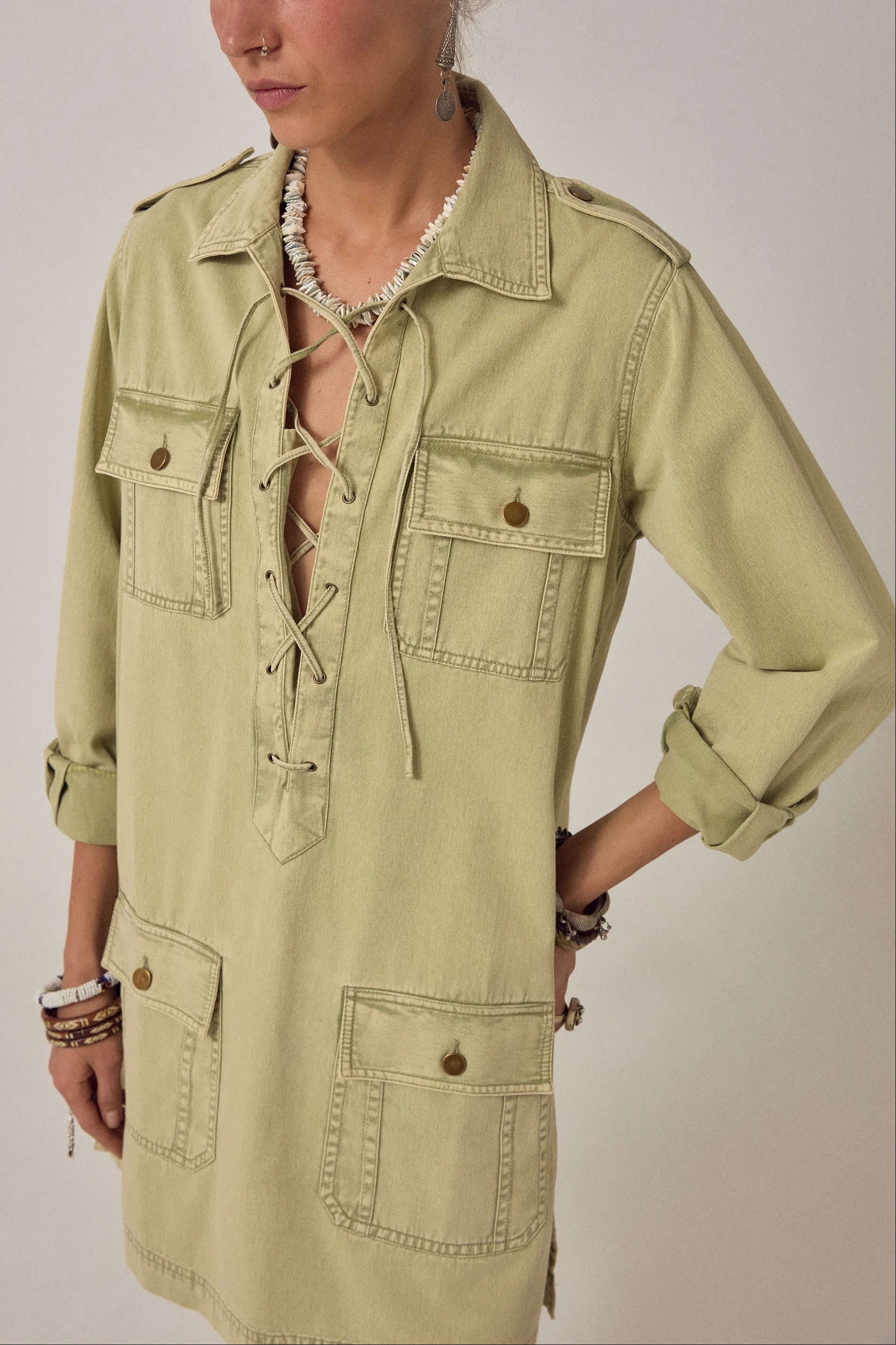 Close-up detail of the Thalassa Short Dress in Army Khaki showcasing the lace-up V-neckline, chest flap pockets, and soft cotton twill fabric.