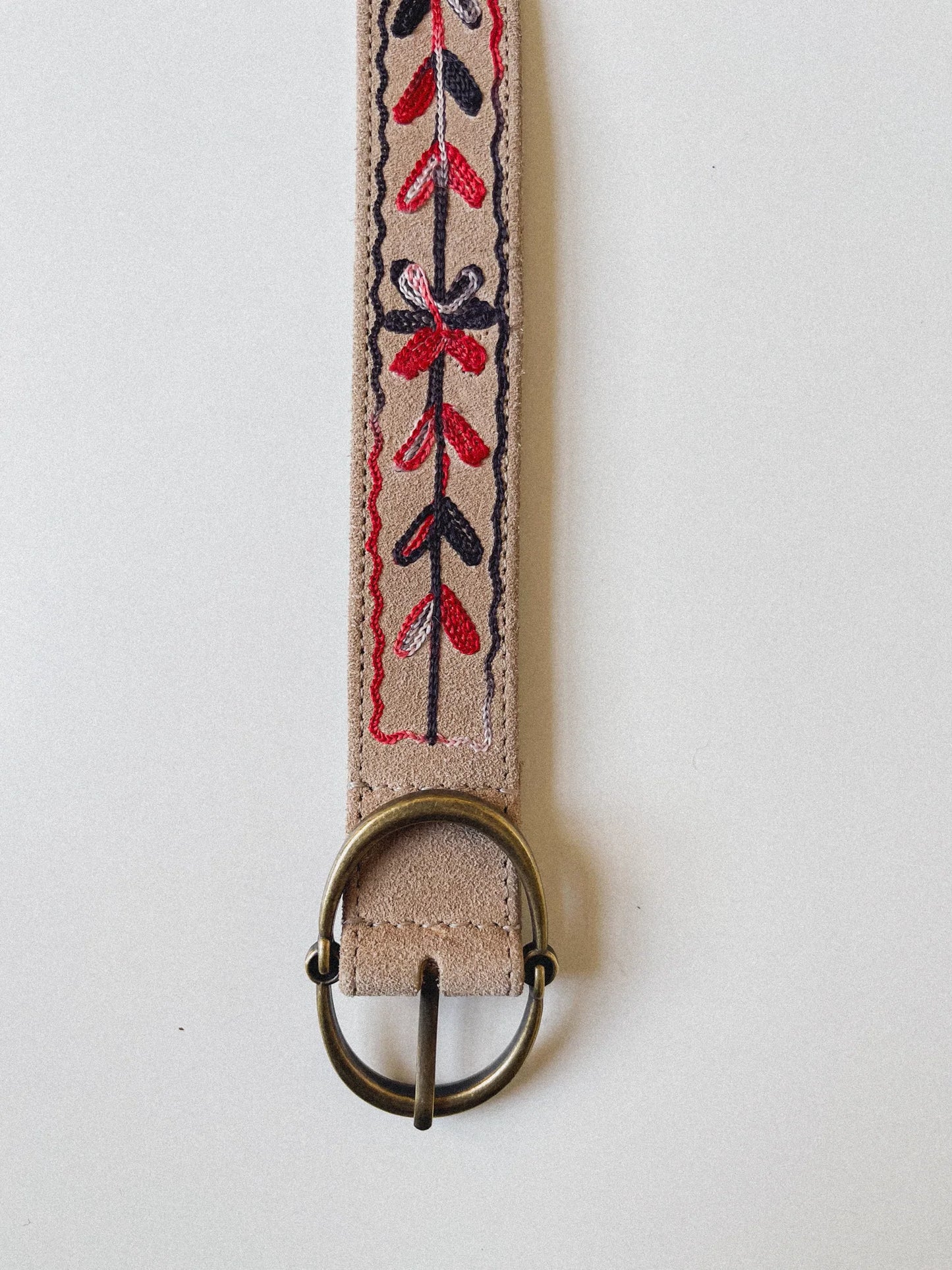 Close-up of the Thar Belt - Karma Thread showing black and red embroidered floral threadwork on desert suede leather.