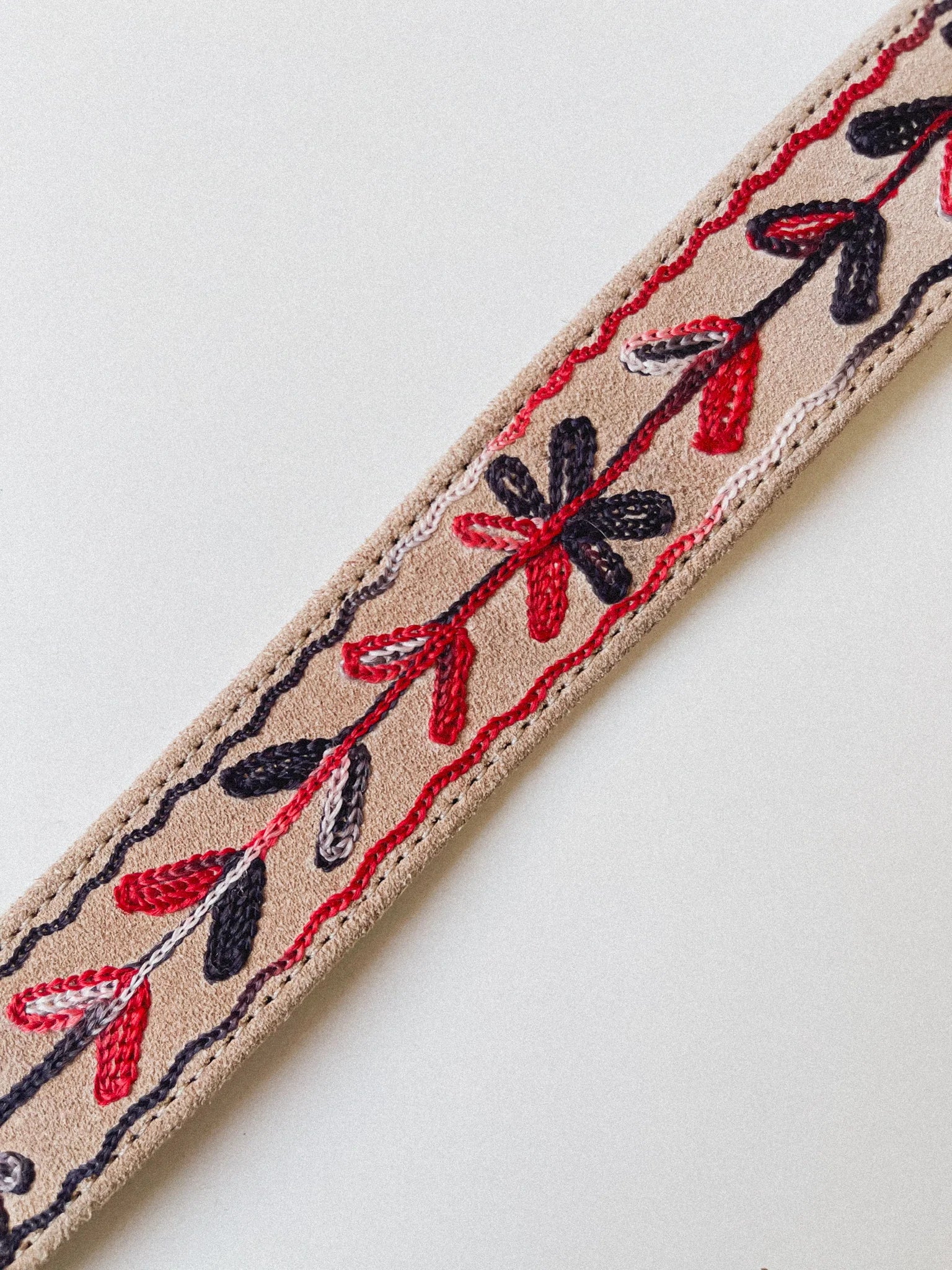 Full view of the Thar Belt - Karma Thread showing the desert suede strap, black and red embroidery, and brass oval buckle.