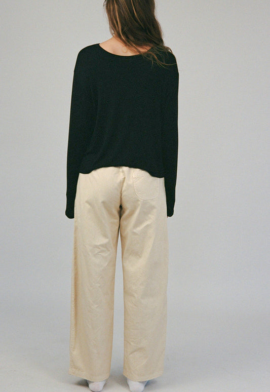 Back view of model wearing The Cozy Tee in Black with a relaxed silhouette and long sleeves