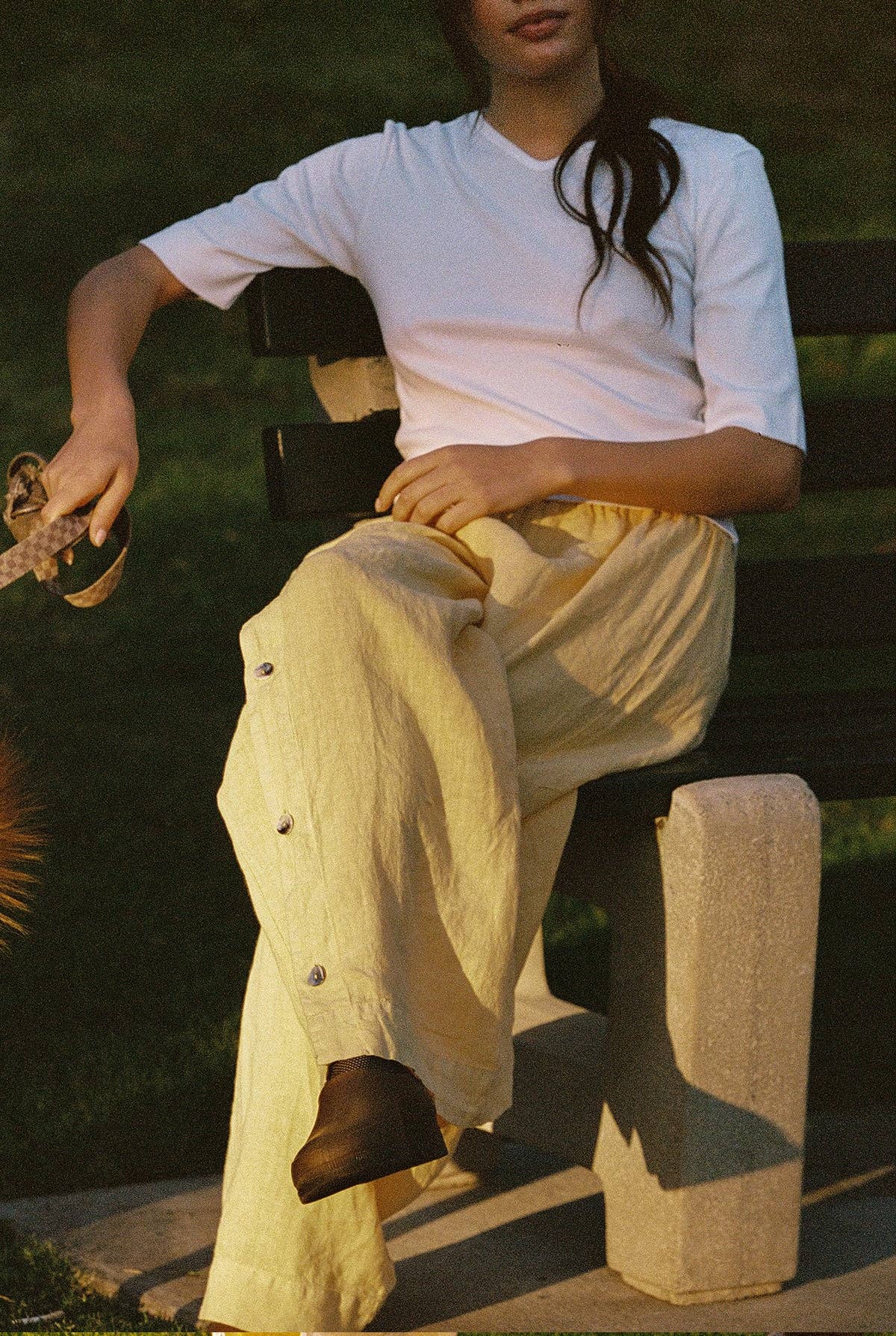 Model seated outdoors wearing Tilda Linen Pant in Sunflower styled with a white fitted tee