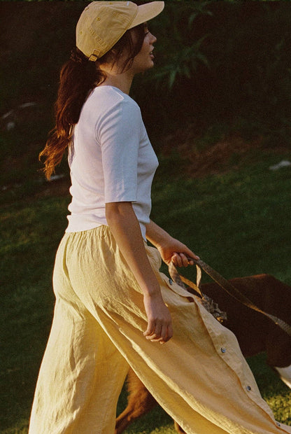 Side profile of model wearing Tilda Linen Pant in Sunflower with adjustable side slit detail
