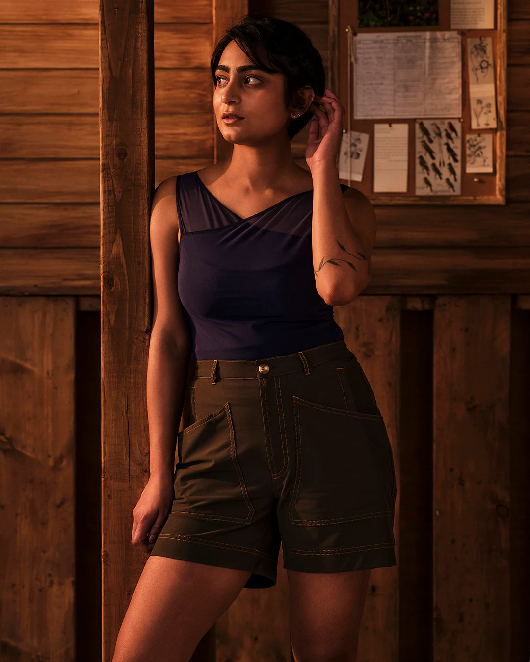Model wearing Trail Tank in Woad styled with trail shorts in outdoor setting