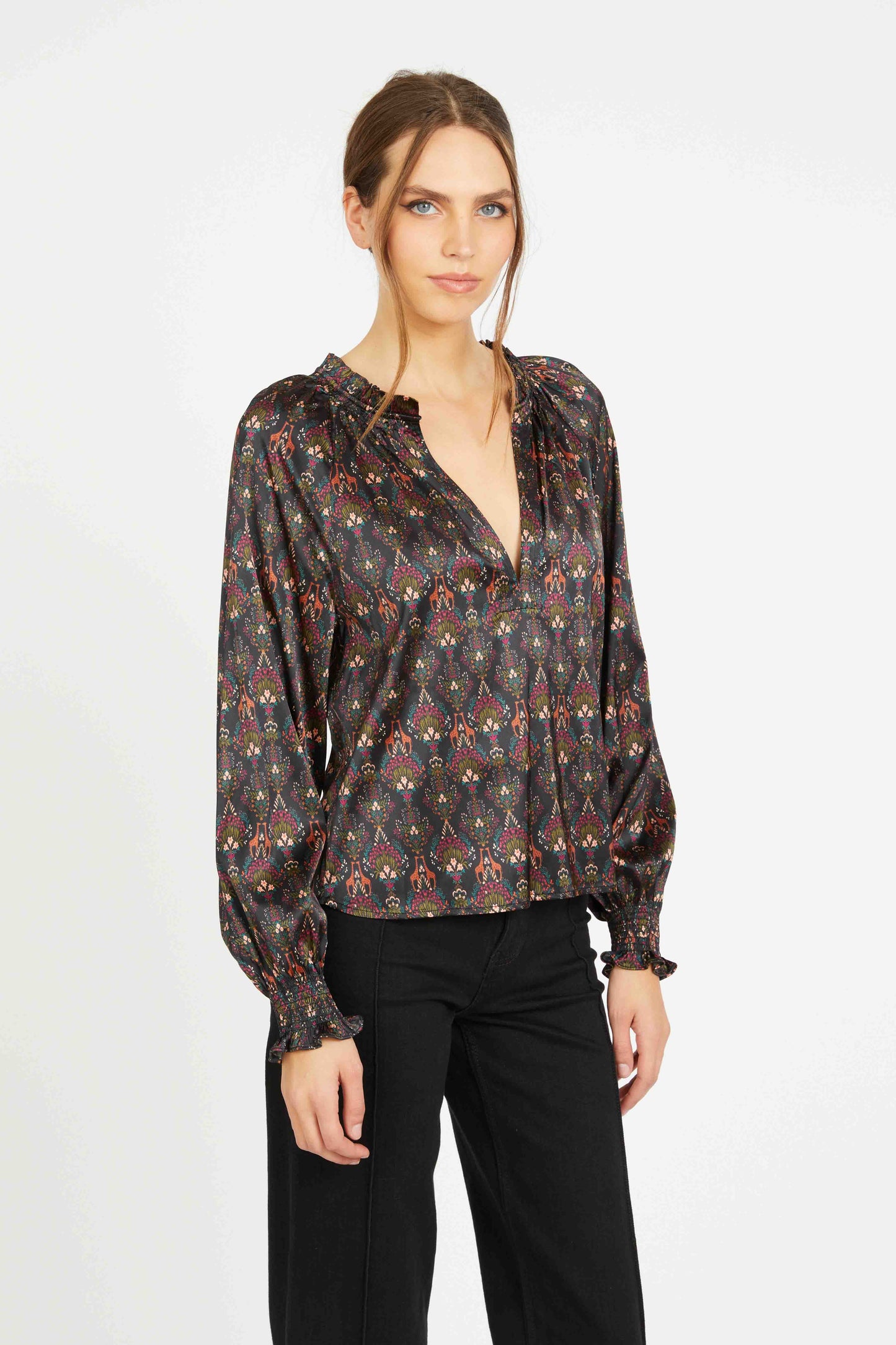 Angled view of the Vickie Top showcasing its fluid satin drape, earthy medallion print, V-neckline, and romantic puff sleeves with ruffled cuffs.